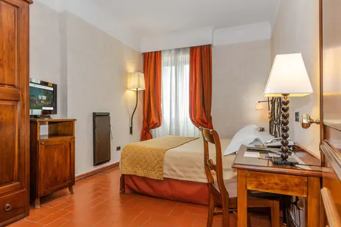 Camera dell'Hotel La Pergola con scrivania e tende rosse