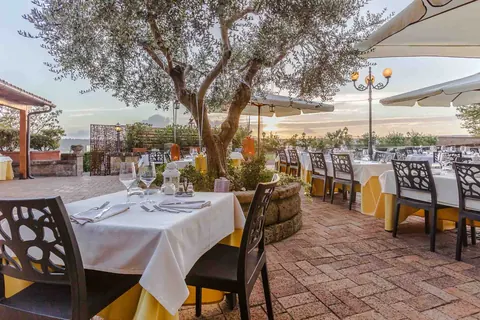 Tavoli apparecchiati in terrazza per la cena all'aperto