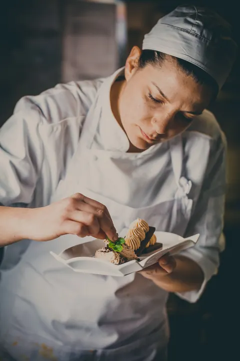La chef impiatta un antipasto in cucina