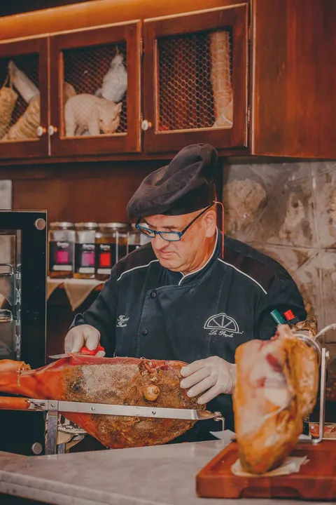 Lo chef taglia il prosciutto al coltello