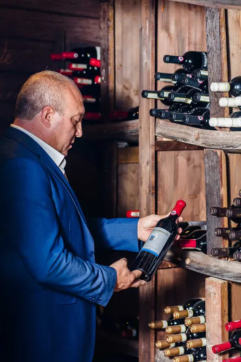 Il titolare sceglie una bottiglia nell'enoteca de La Pergola