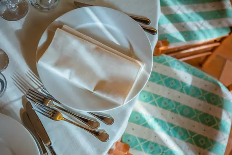 Mise en place con tovagliolo e posate