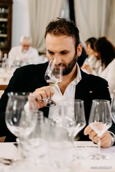 Ospite annusa un calice di vino bianco