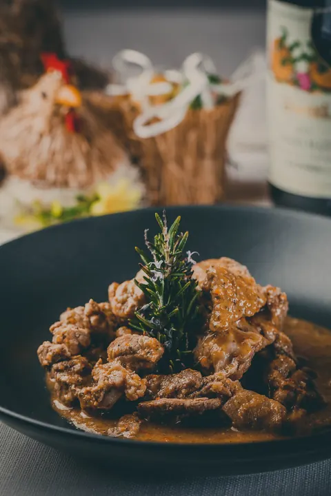 Spezzatino al rosmarino servito con vino rosso