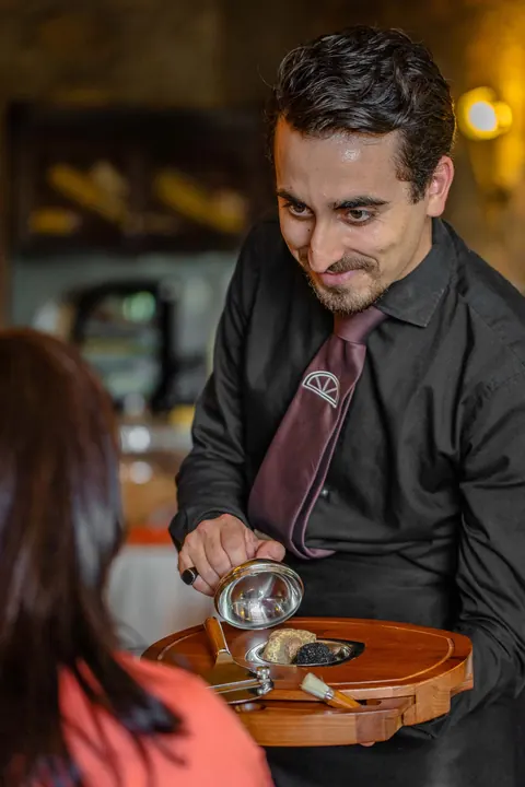 Il cameriere grattugia il tartufo al tavolo